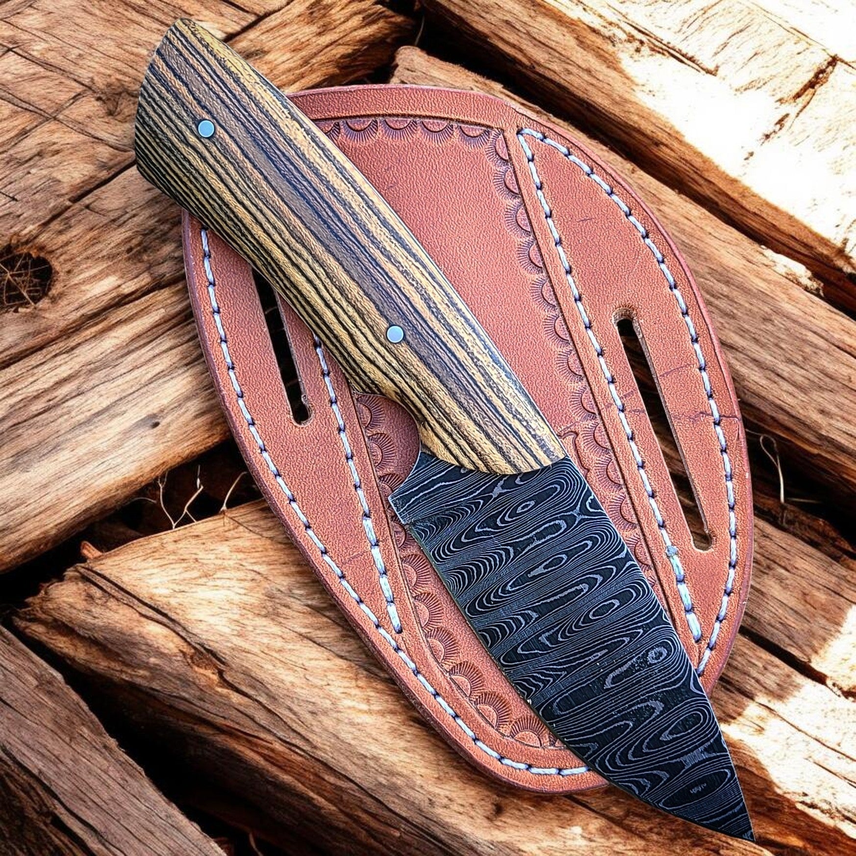 Cowboy Hash Knife with a Damascus steel blade and leather sheath on wooden background